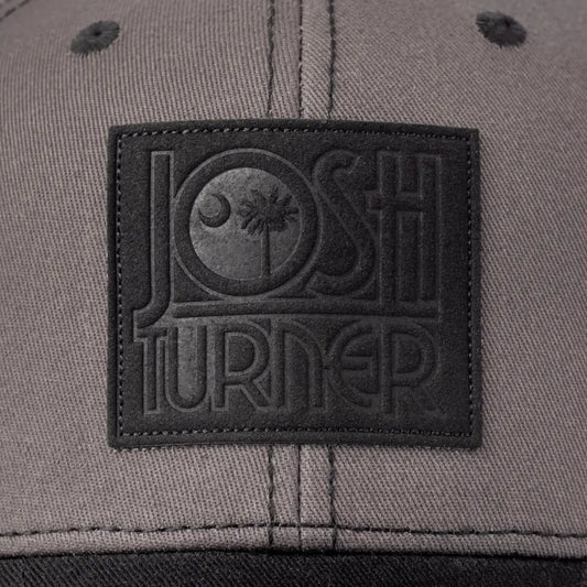 Gray baseball cap with a black embroidered patch featuring the text ’JOSH TURNED’.