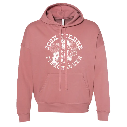 A soft rose-colored hoodie featuring a white circular graphic of a musician with fireworks and the text ’josh turner firecracker.’