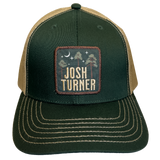 Trucker-style baseball cap with a dark green front, tan mesh back, and a square patch featuring the name ’Josh Turner’.