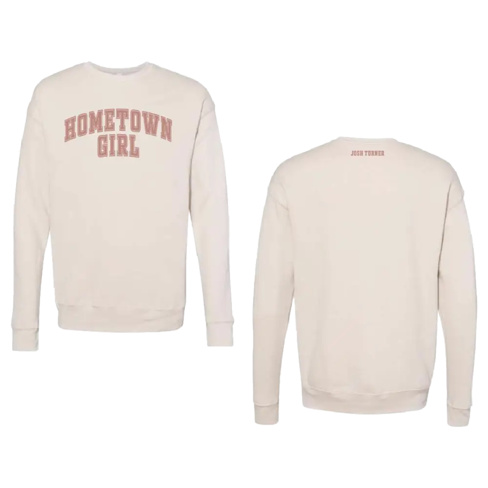 Cream-colored sweatshirt with ’hometown girl’ printed in faded red arched lettering across the chest and a small brand tag on the back.