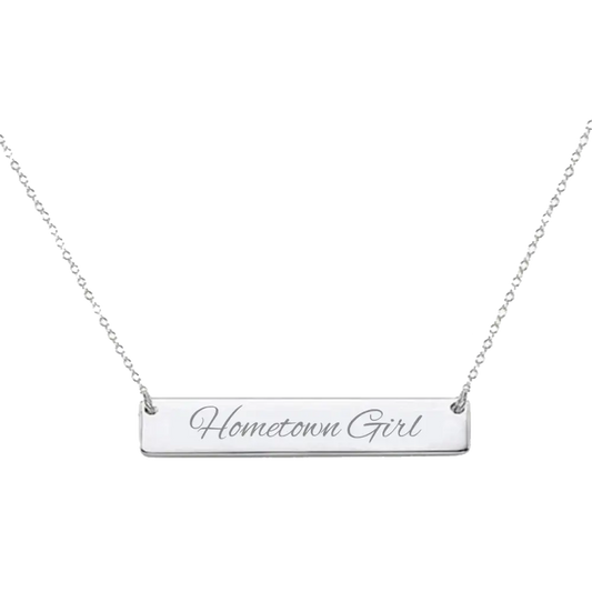 Silver bar necklace engraved with ’Hometown Girl’ on a delicate chain.