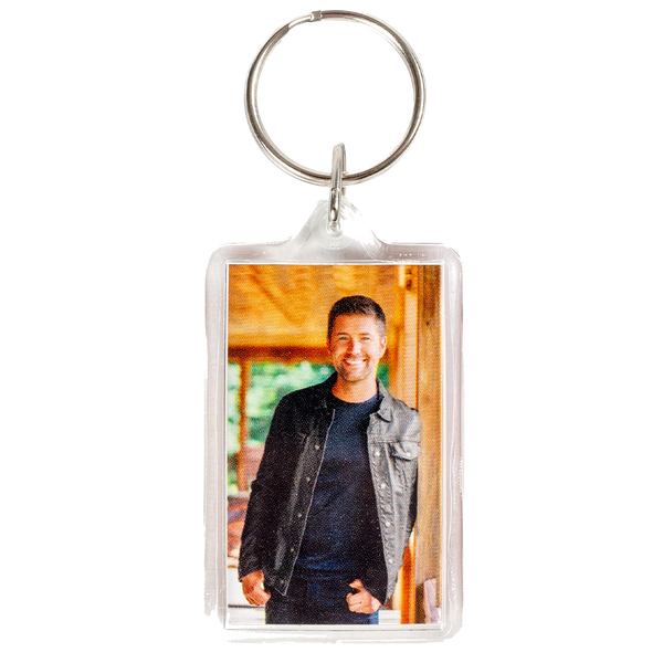 Keychain with a photo insert displaying a smiling person in casual attire.