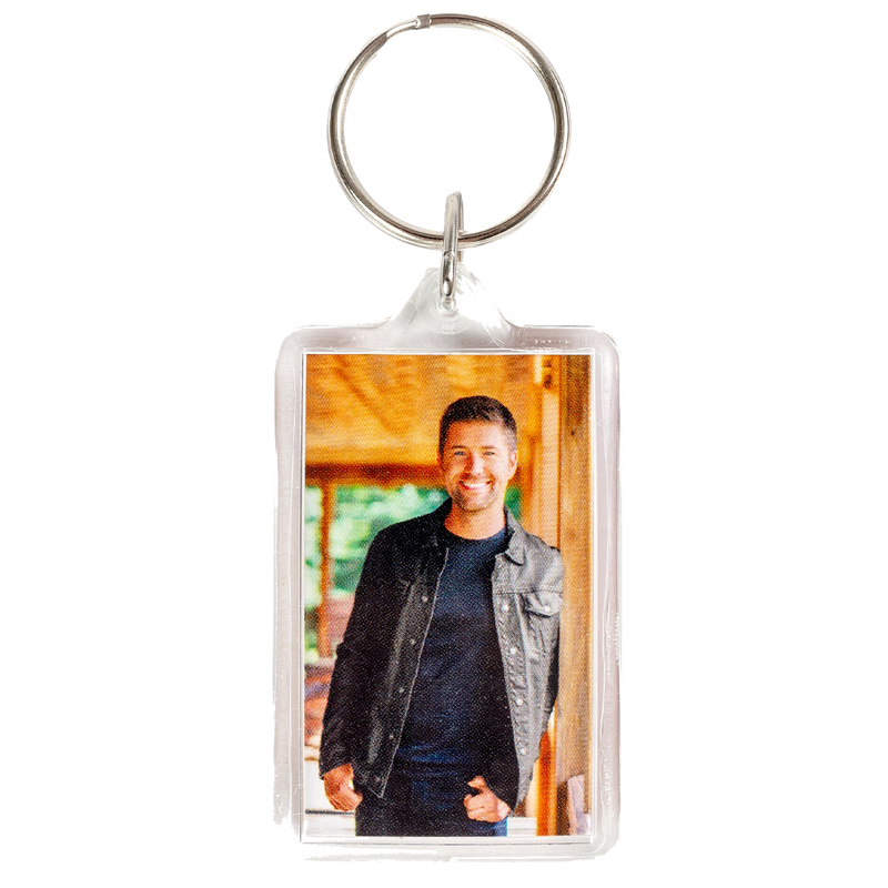 Keychain with a photo insert displaying a smiling person in casual attire.