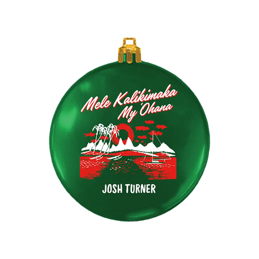 Green Christmas ornament with Hawaiian-themed design and text.