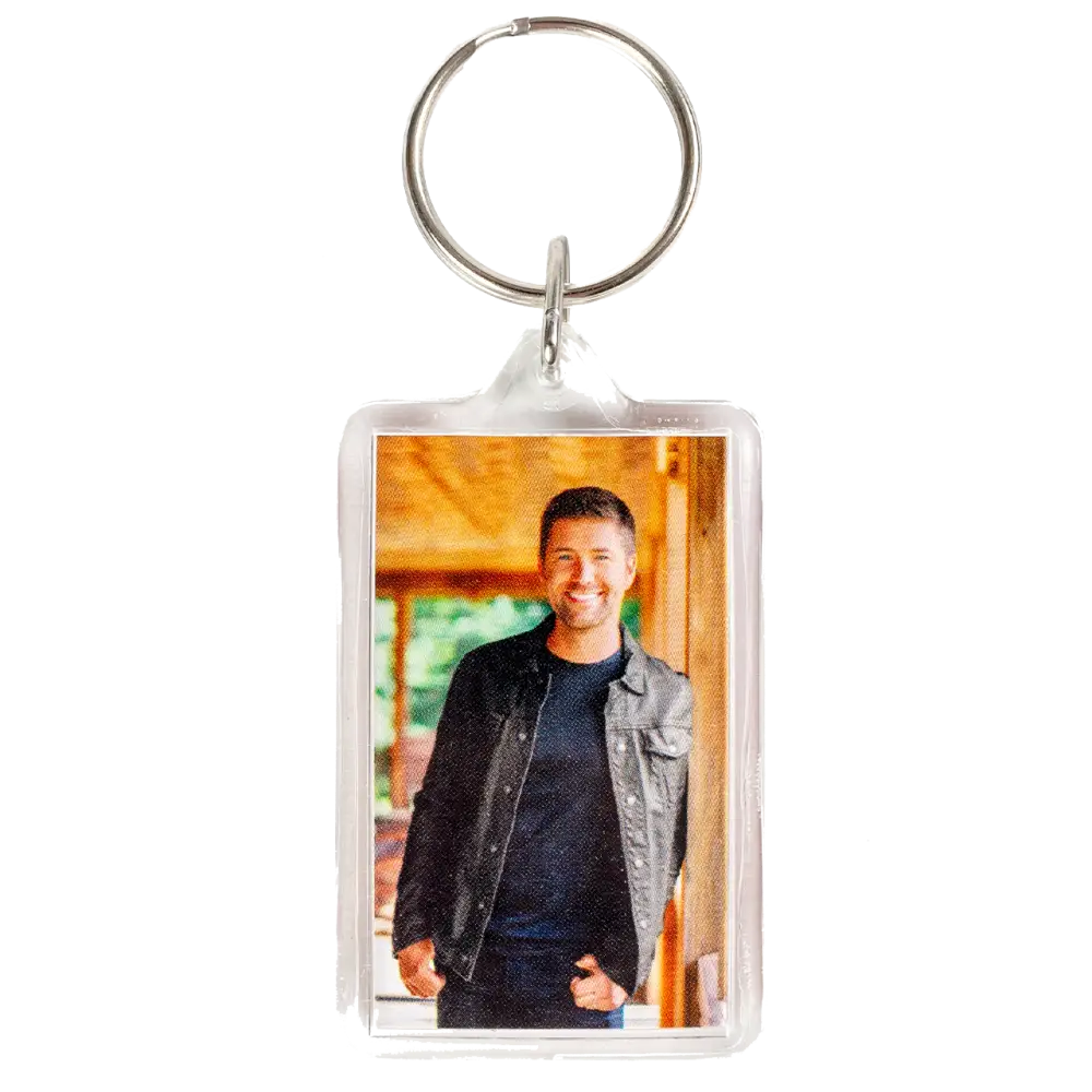 Keychain with a photo insert displaying a smiling person in casual attire.