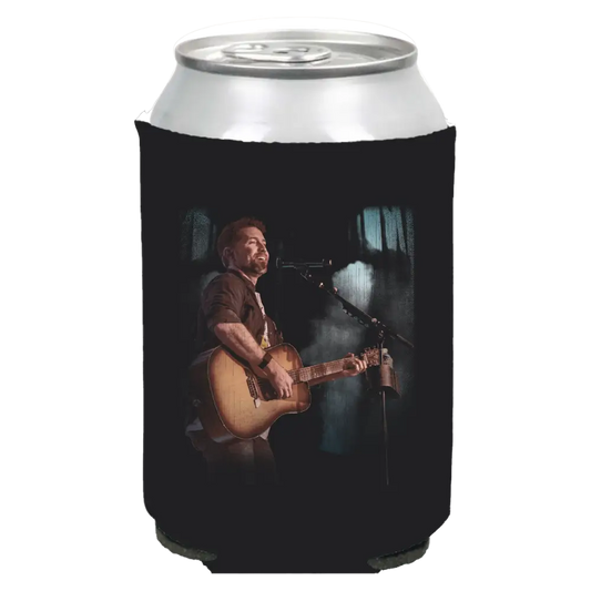 Black foam drink cooler sleeve with an image of a musician performing on stage printed on it.