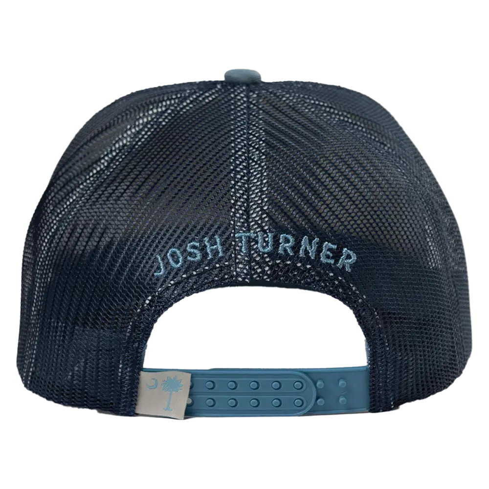 Dark navy mesh trucker hat with ’josh turner’ embroidered in light blue thread and a matching teal plastic adjustable strap featuring a beige tag with a pale blue palmetto tree logo.