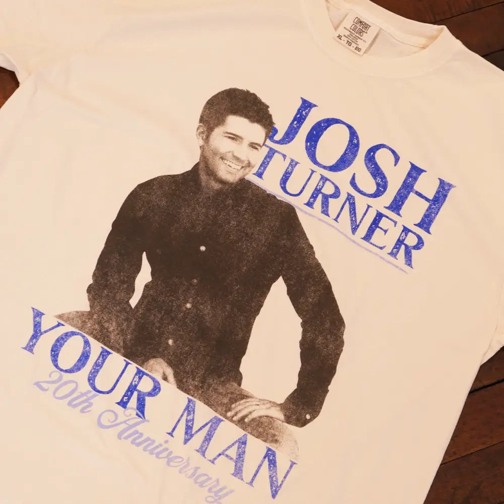 Off-white cotton t-shirt featuring a distressed blue print of singer josh turner with the text ’your man 20th anniversary’ beneath his image.