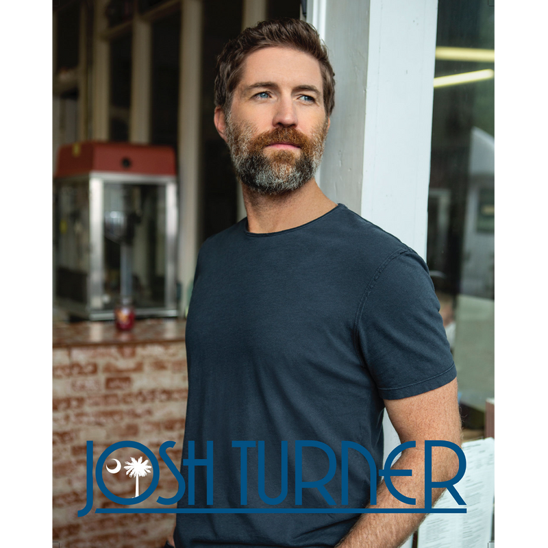 Man with a beard wearing a dark blue t-shirt.