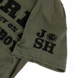 Olive green t-shirt sleeve with ’JOSH’ printed in black letters.