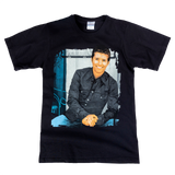 Black t-shirt with a printed photograph of a smiling man in a dark shirt on the front.