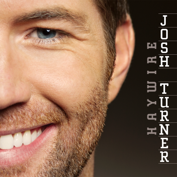 Close-up partial view of a smiling man’s face with beard stubble.